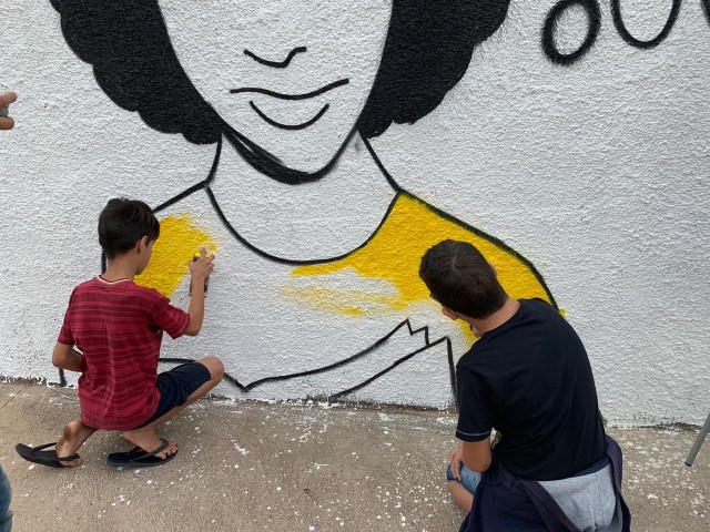 Alunos e artistas promovem pintura interativa em muro da Escola Pastor João Carlos